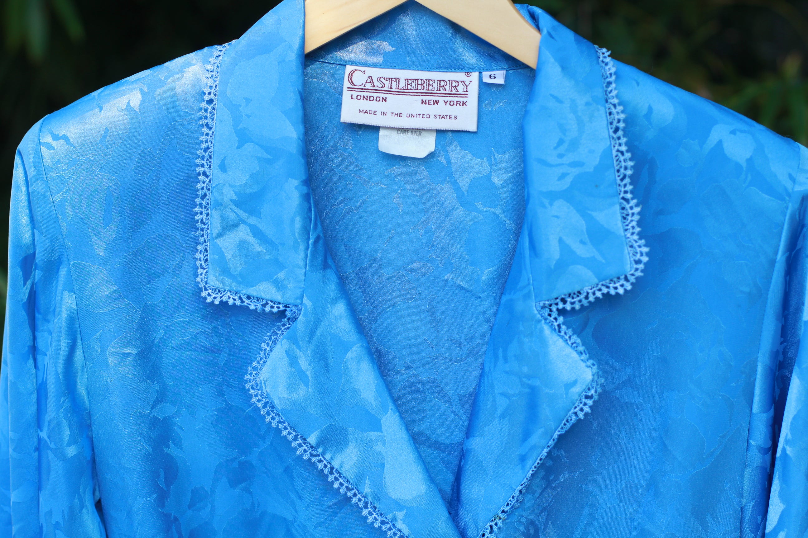 Detail of double‑breasted blouse with padded shoulders