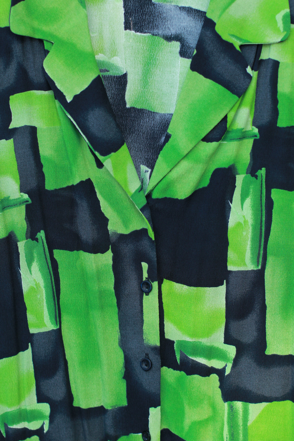 Close-up of green and black multicolor print and buttons on vintage Gianni blouse