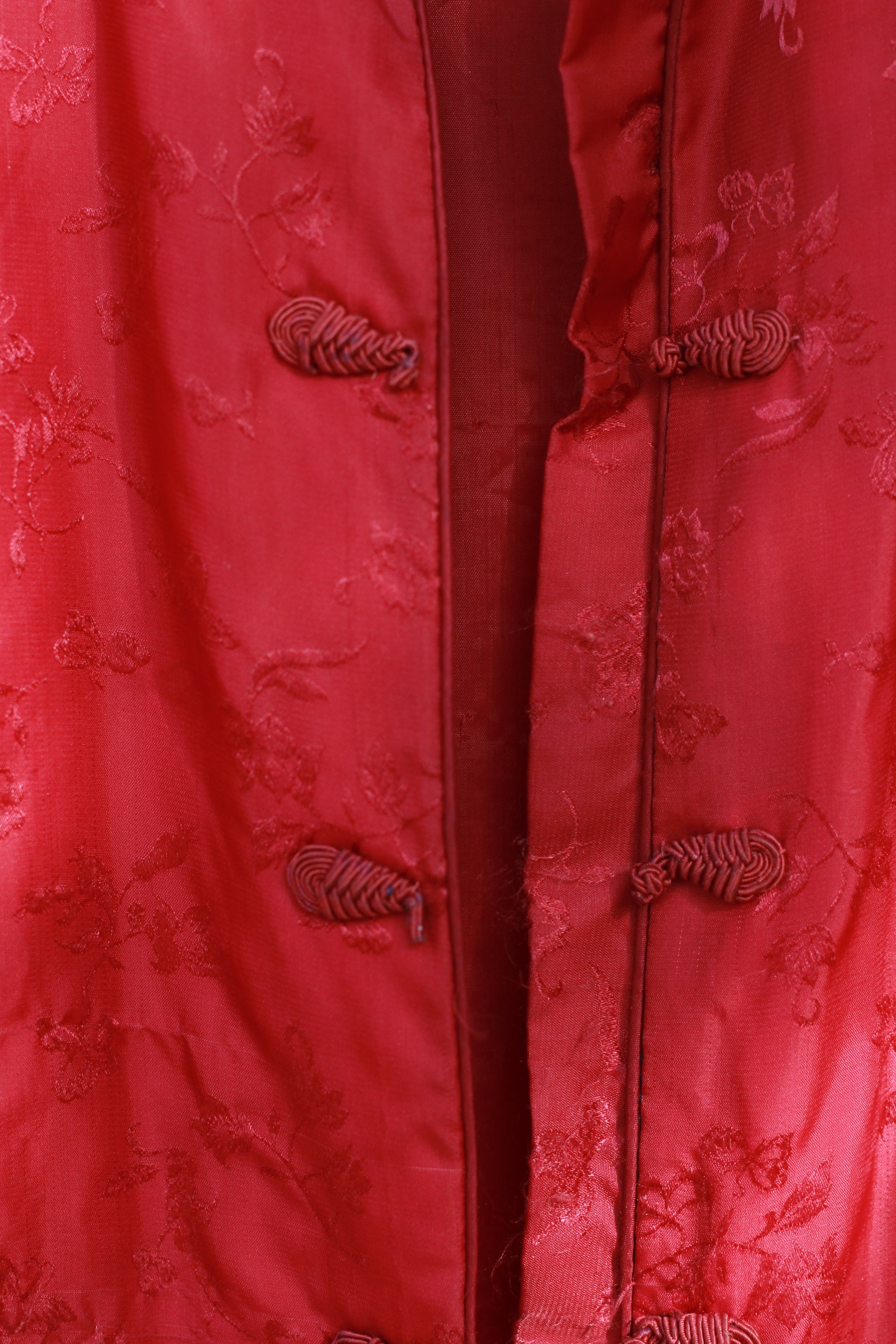 Close-up of frog closures and floral brocade detail