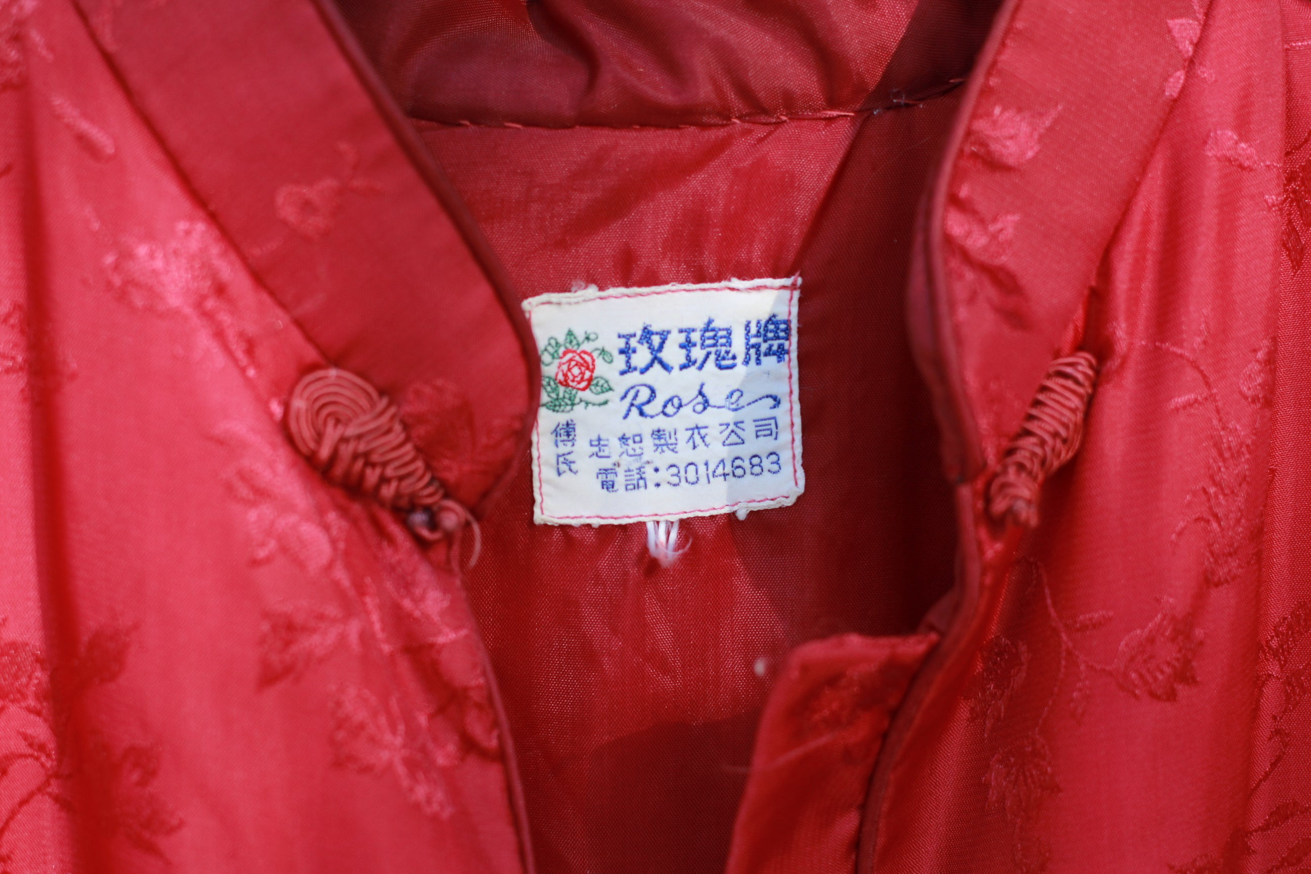Close-up detail of tag on satin brocade Chinese-style quilted jacket