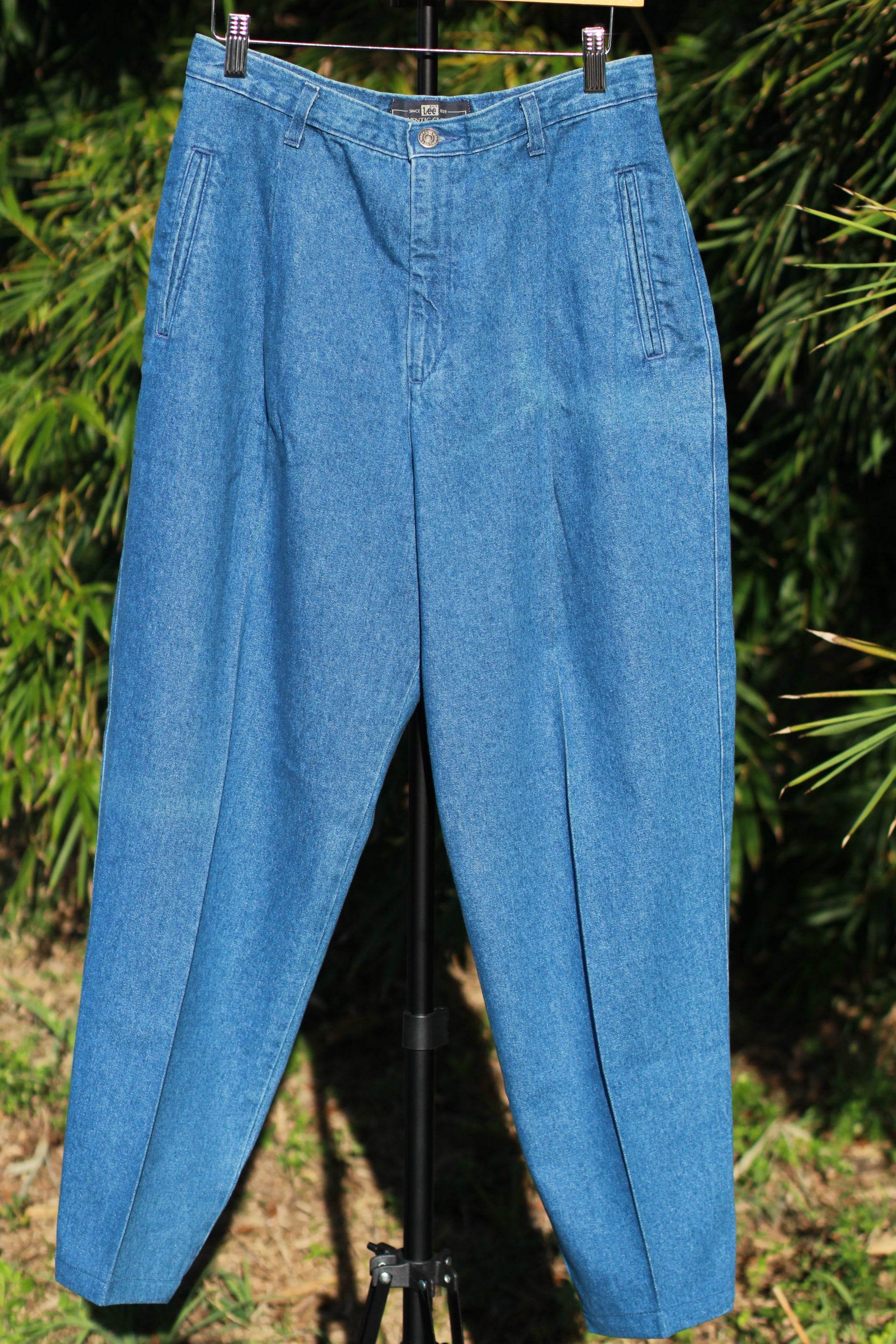 Front view of vintage 90s Lee pleated tapered jeans in mid blue wash