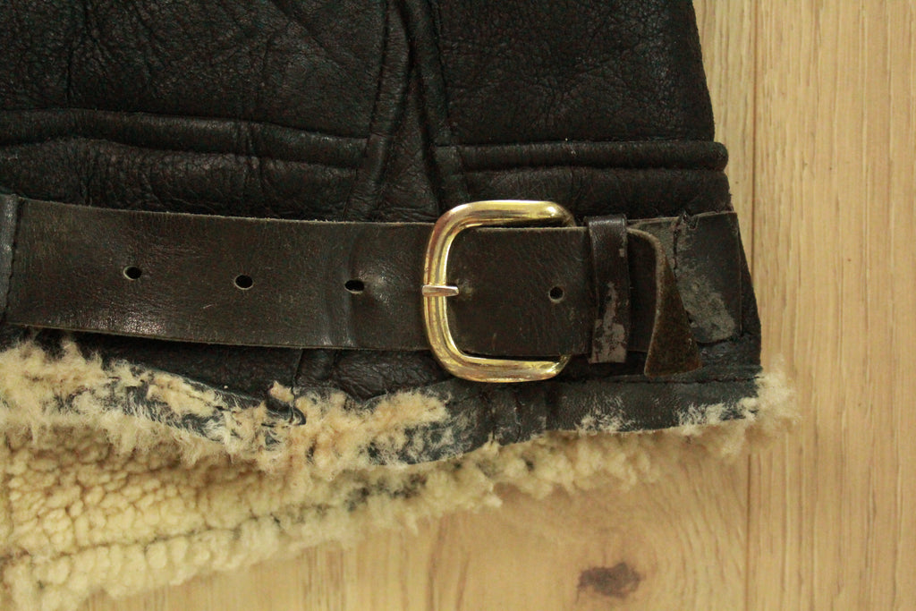 Close-up of wear on right hem buckle on Vintage Black B3 Shearling Bomber Jacket