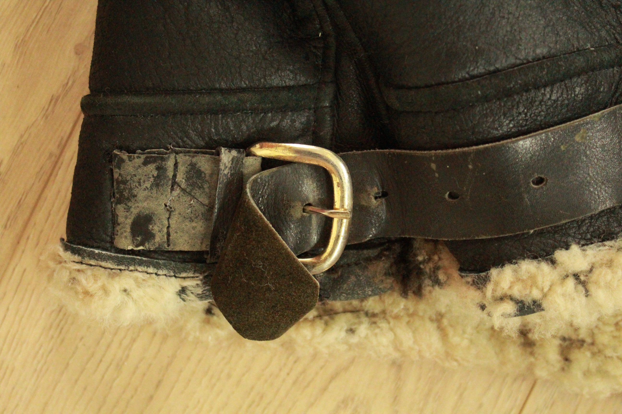 Close-up of wear on left hem buckle on Vintage Black B3 Shearling Bomber Jacket