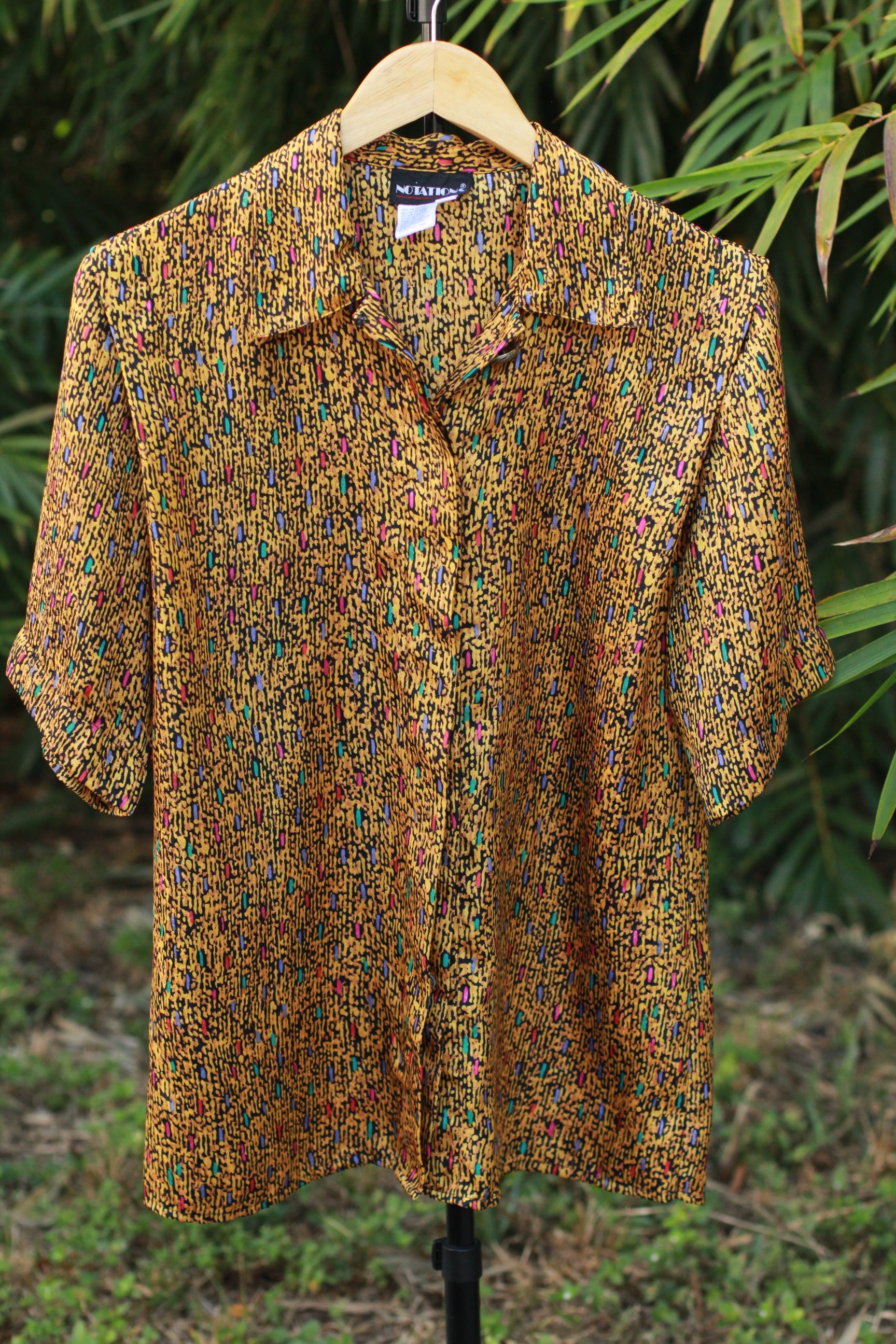Front view of retro abstract button-up shirt with statement collar button, size 10.