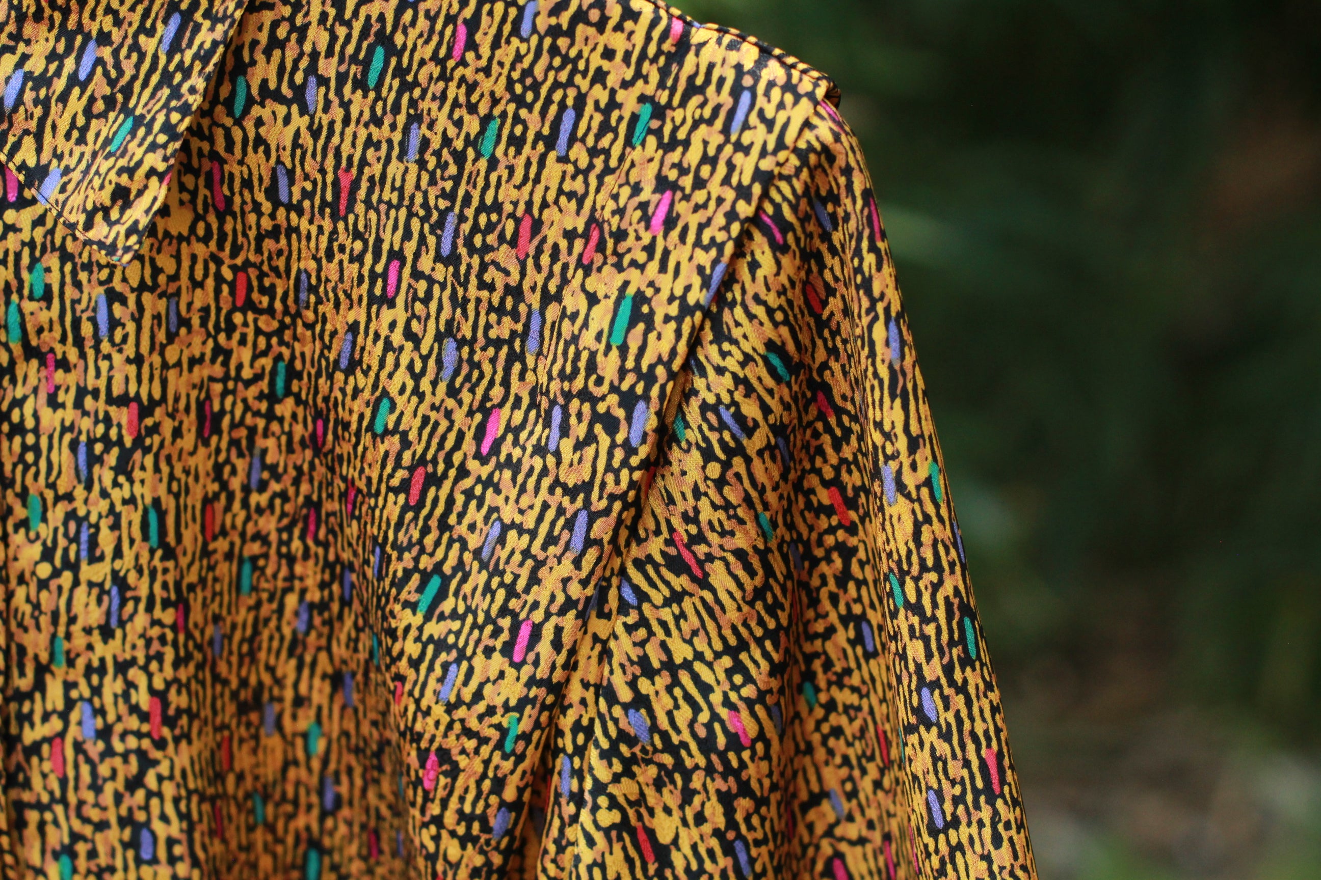 Close-up of gold and multicolor abstract pattern on vintage Notations short-sleeve blouse.