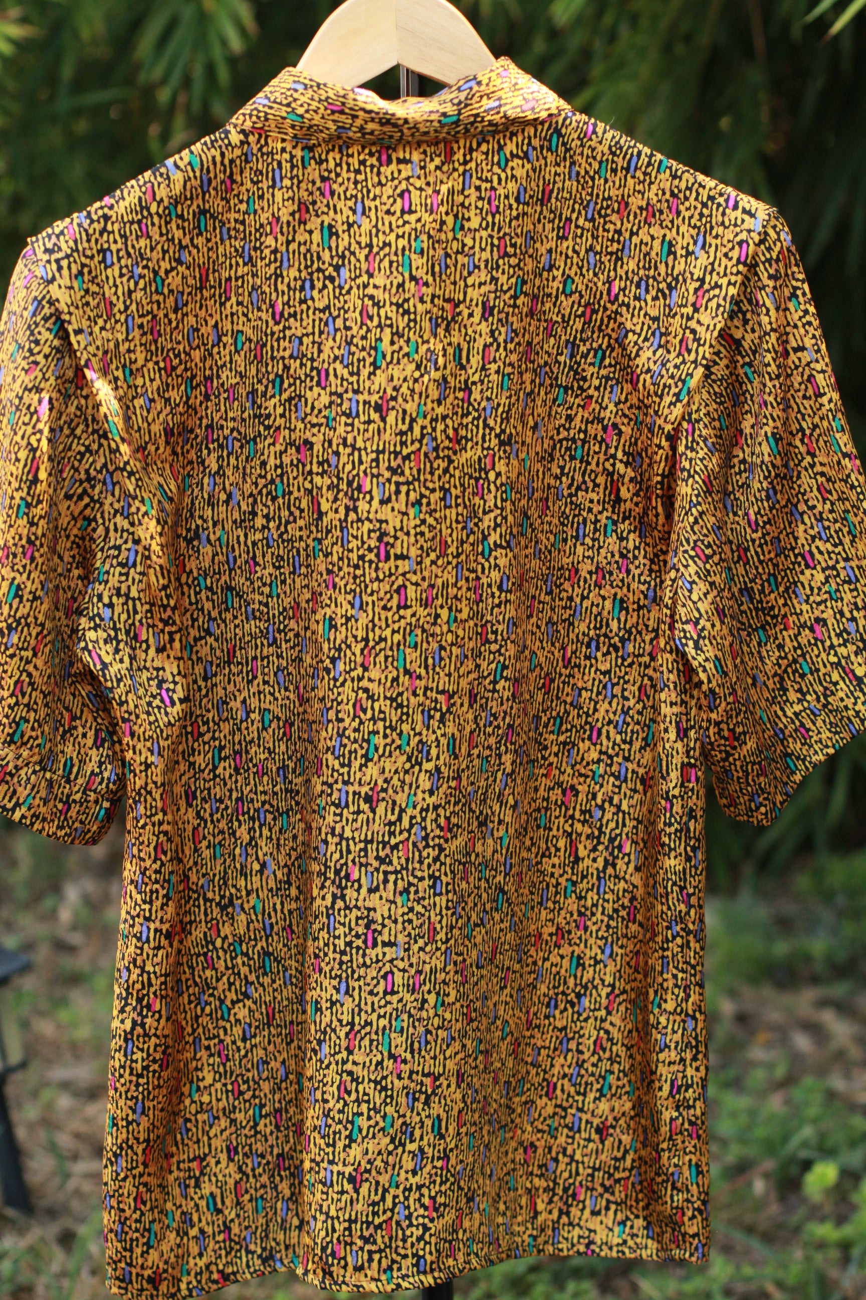 Back view of women’s vintage abstract print shirt with short sleeves.