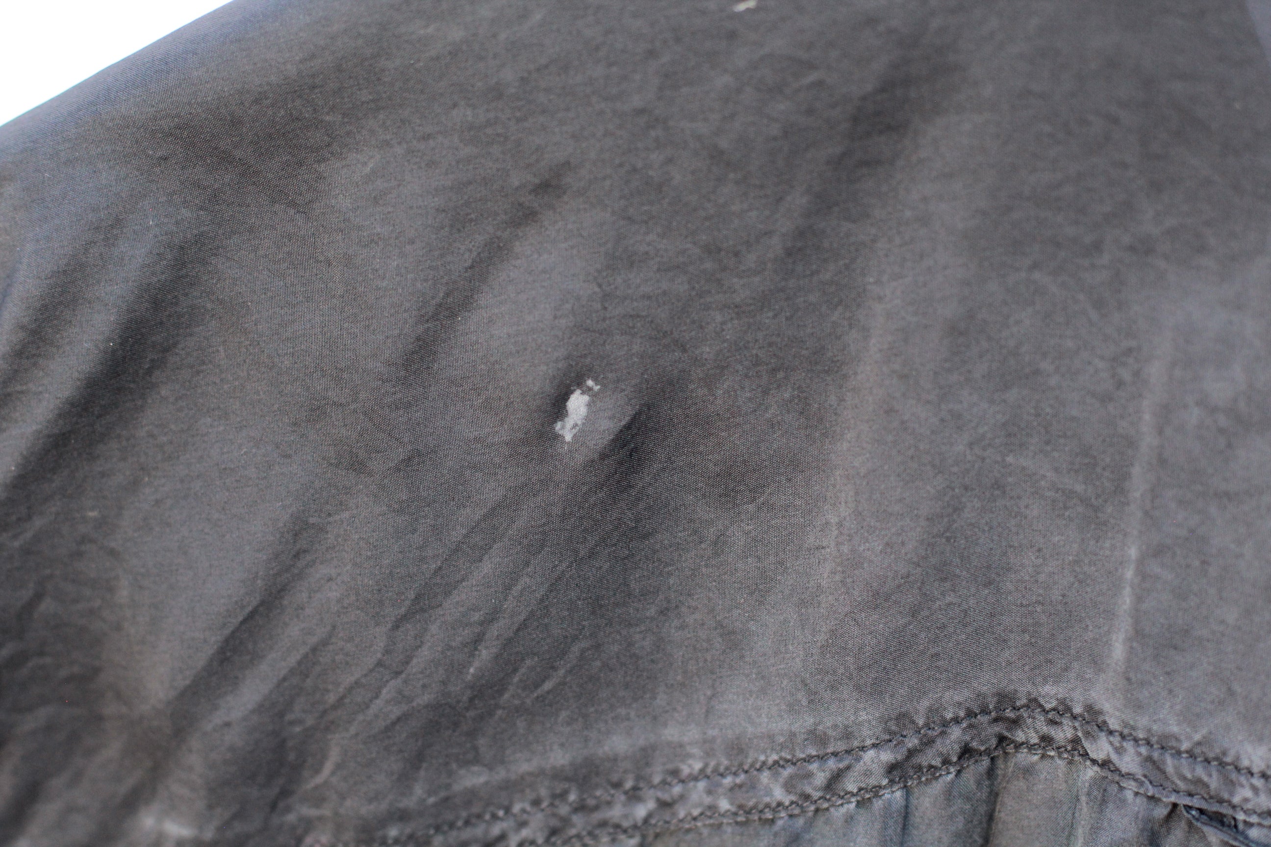 Close-up of blemish on vintage silk button-up shirt back shoulder