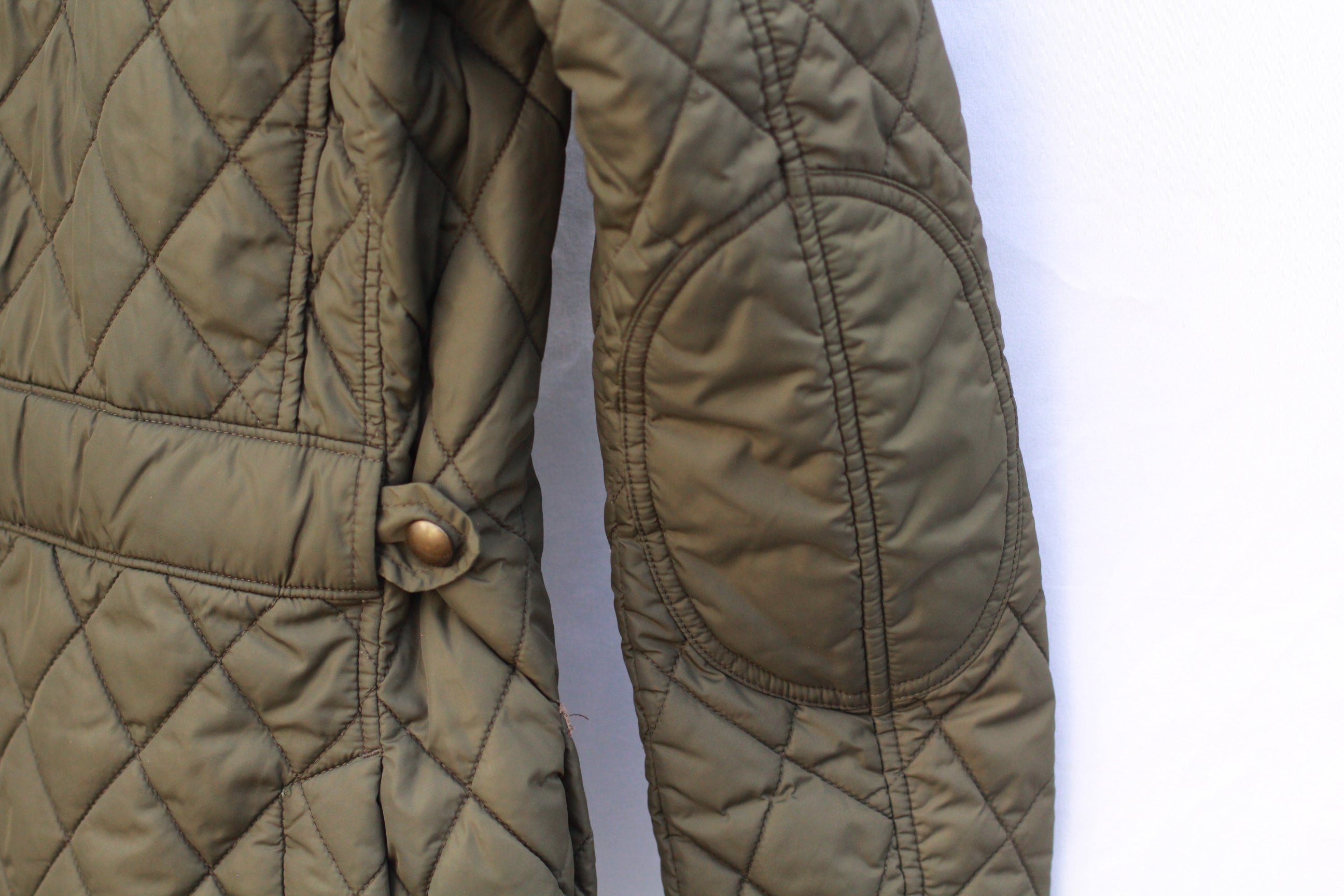Back elbow view of Polo Ralph Lauren hunter green quilted riding jacket