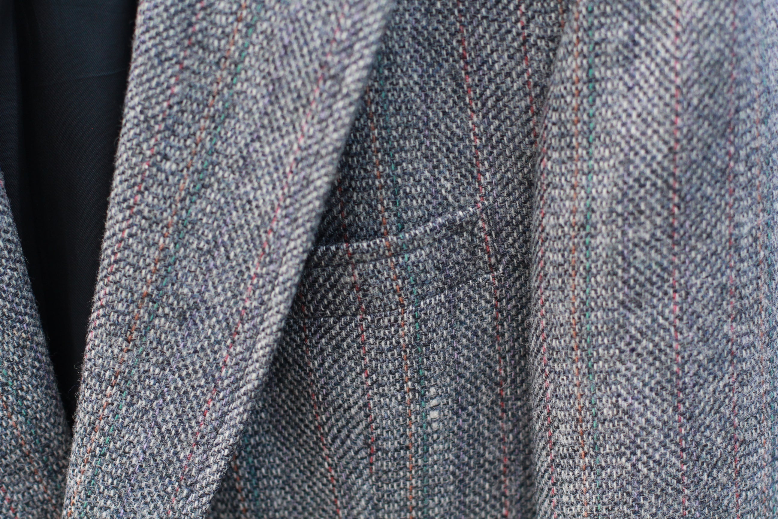 Detail of notch lapels and chest pocket on gray tweed blazer