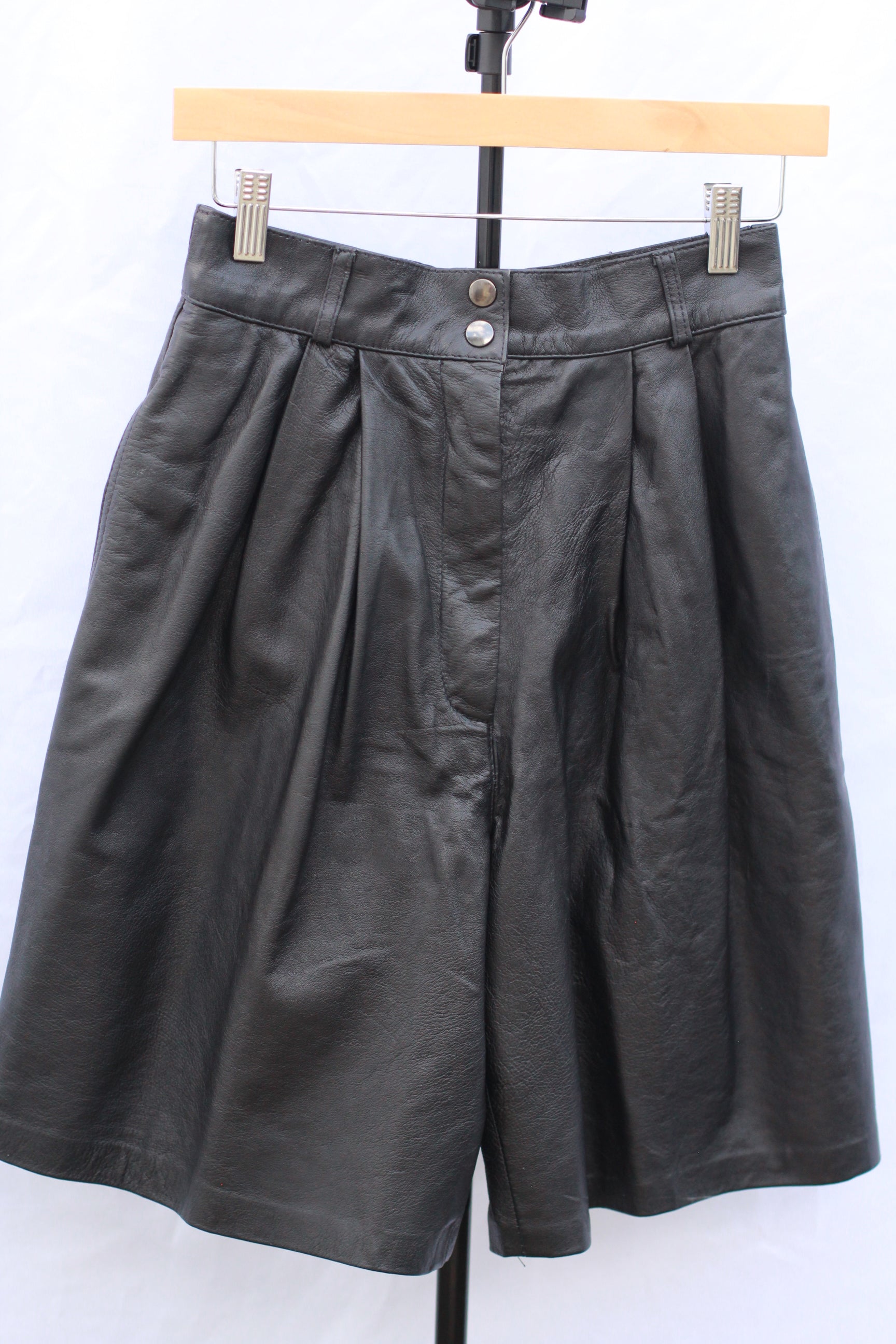 Vintage 90s high-rise black leather pleated shorts with 26-inch waist and 8-inch inseam