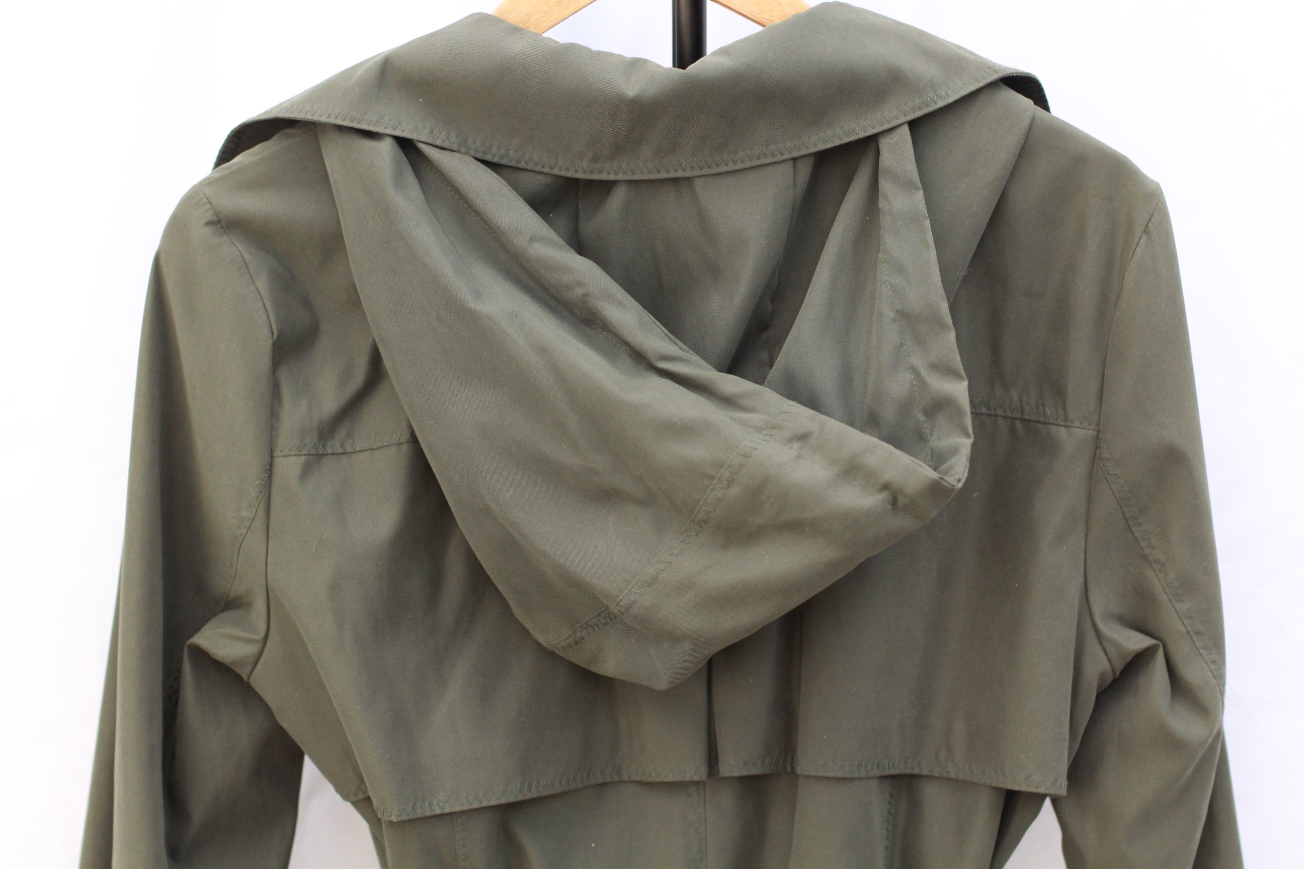 Detail of removable hood on green trench coat