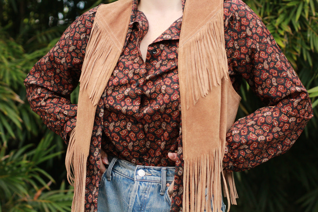 Model wearing vintage paisley blouse styled with suede fringe vest