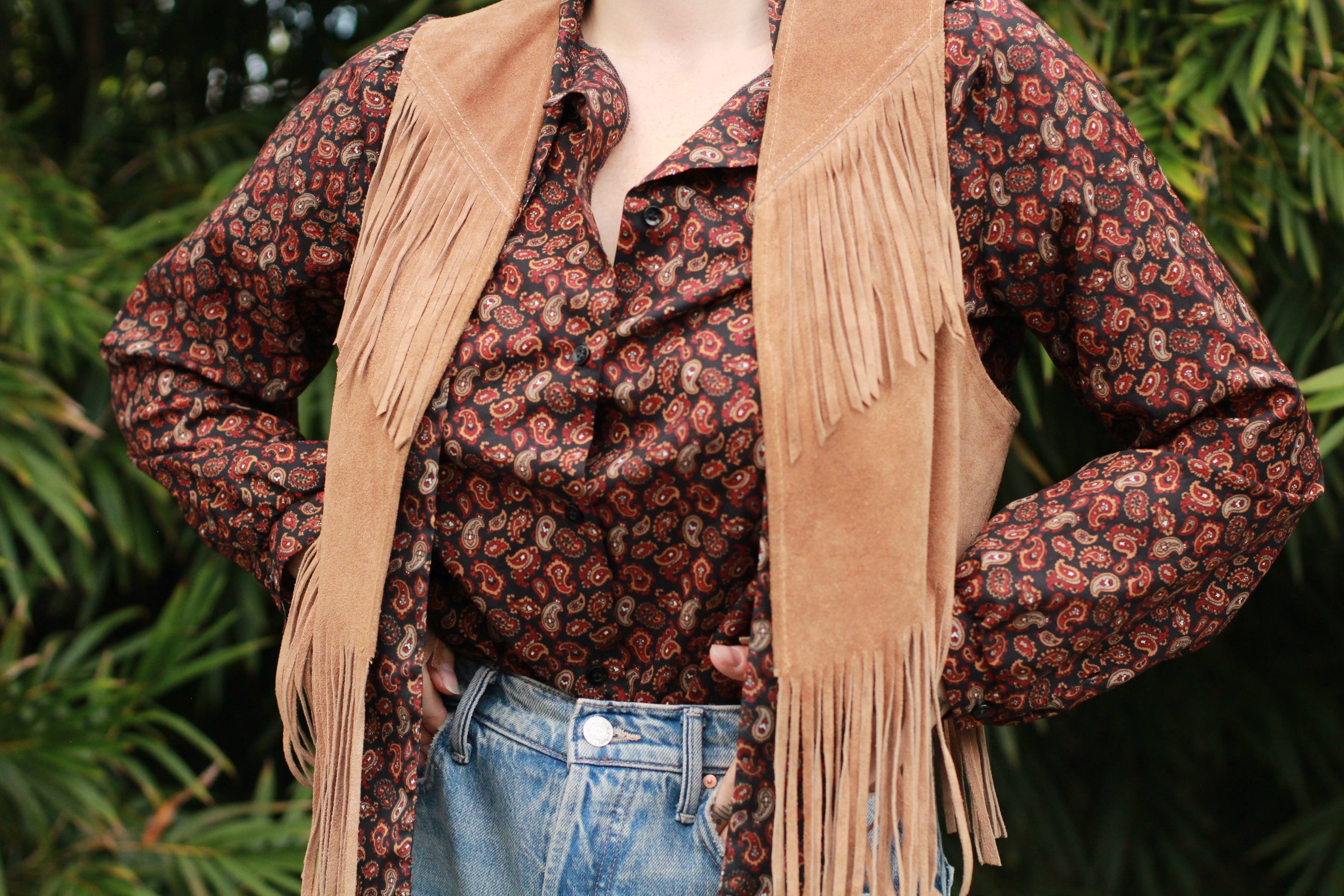 Model wearing vintage paisley blouse styled with suede fringe vest