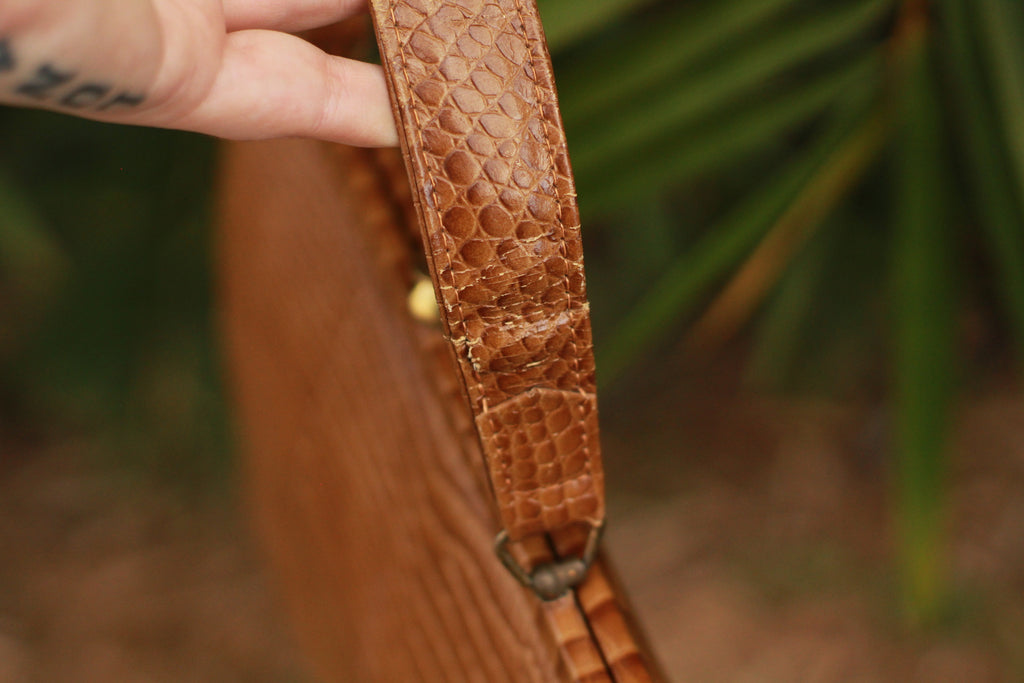 Close-up of natural wear on top-handle of 1960s crocodile embossed leather handbag
