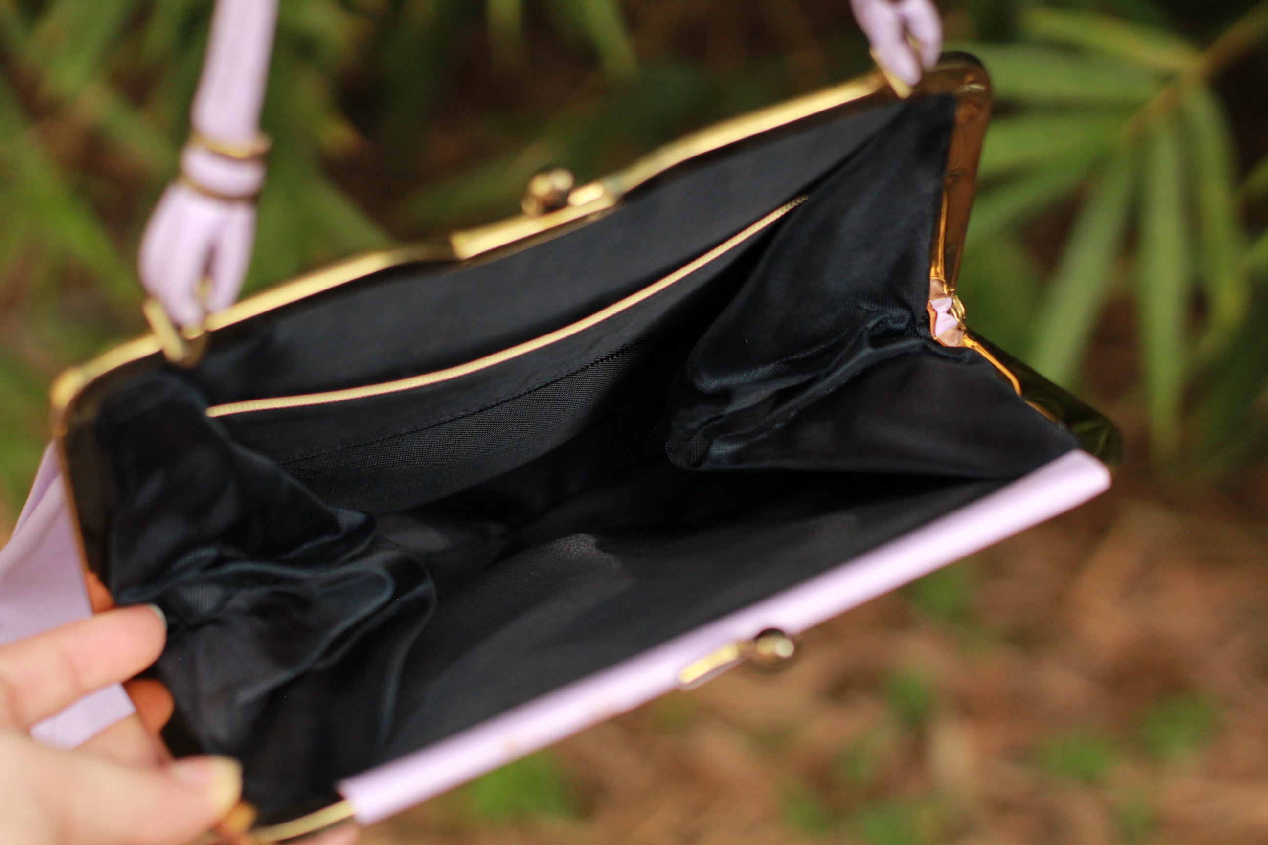 view of inside vintage lavender kiss-lock handbag with gold-tone hardware