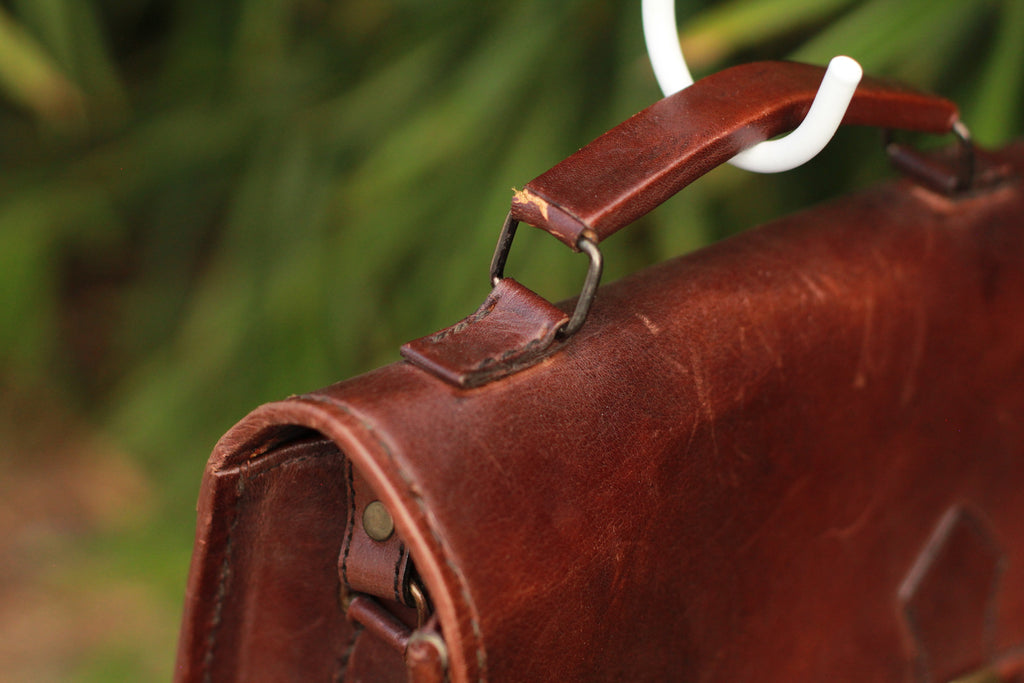 Top-handle showing cracking on vintage handmade leather messenger bag