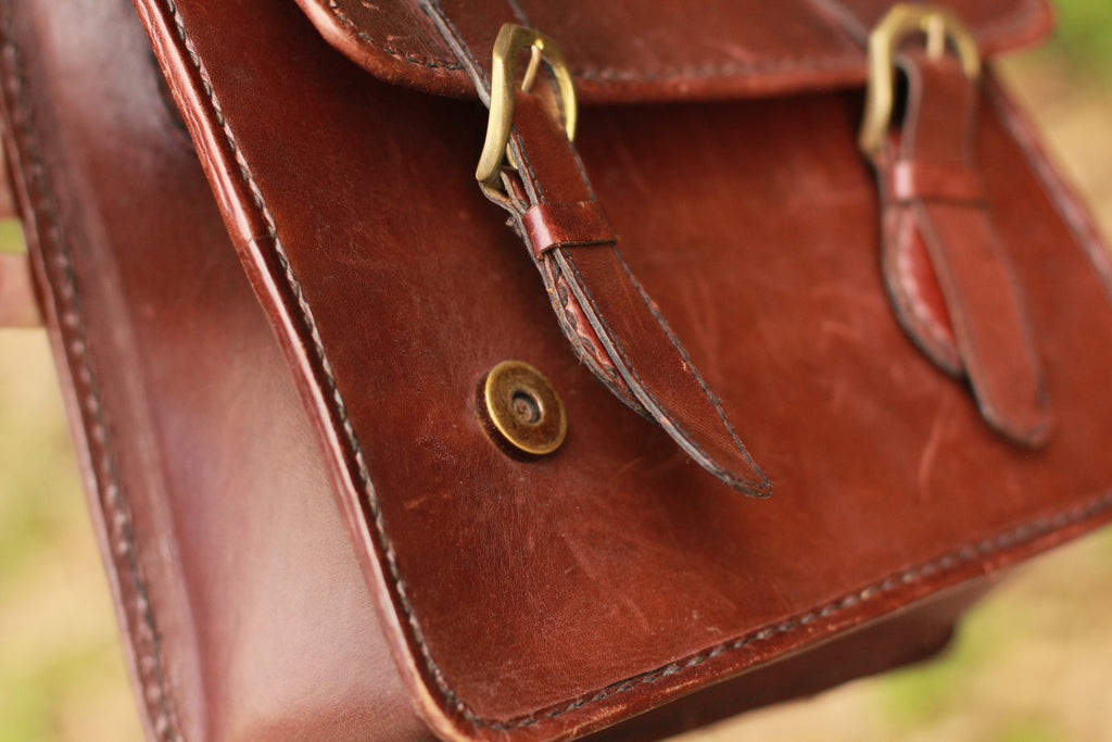 Brass hardware magnetic closures on leather messenger bag