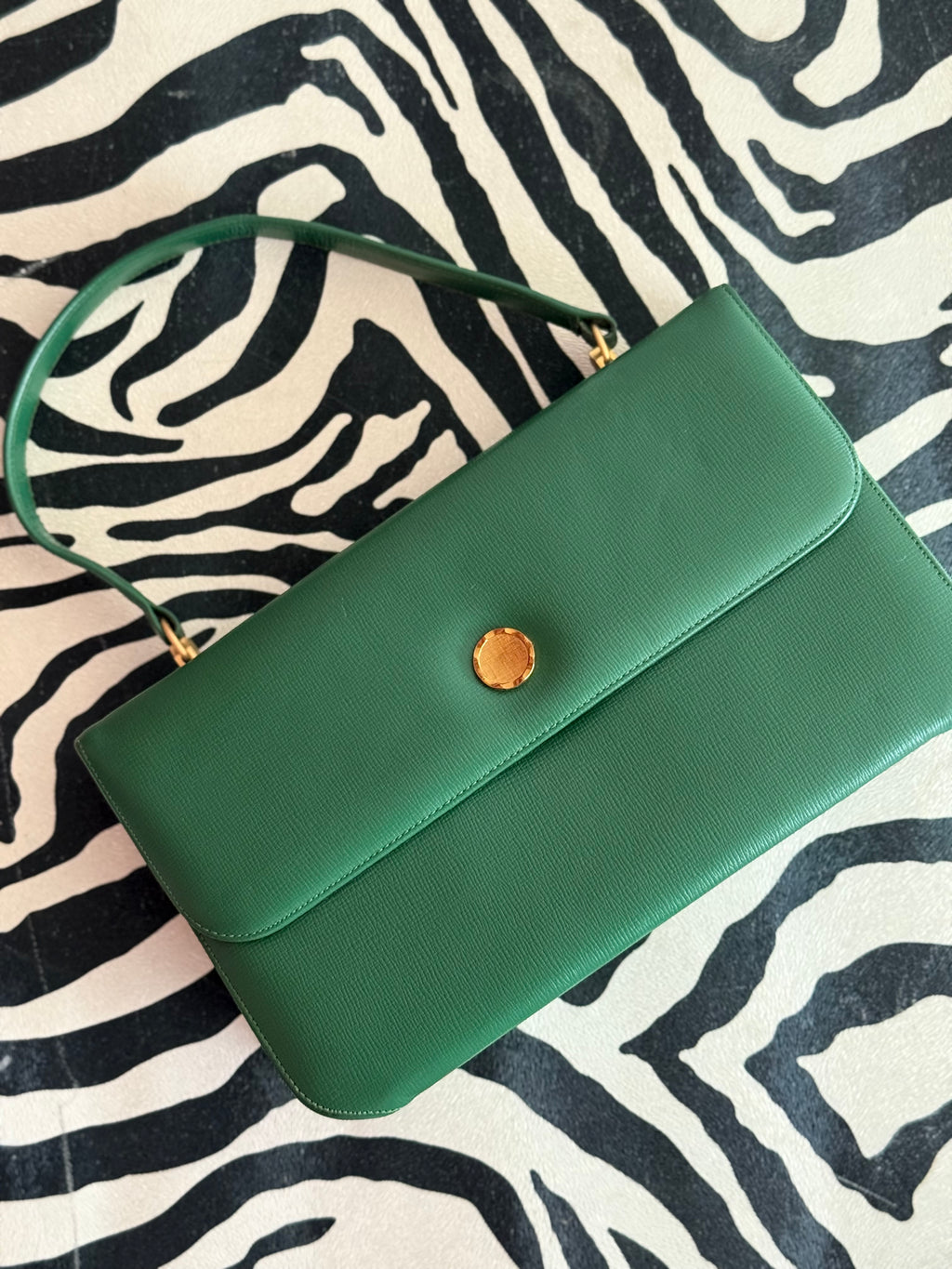 Front view of vintage 1990s green leather handbag with gold button clasp