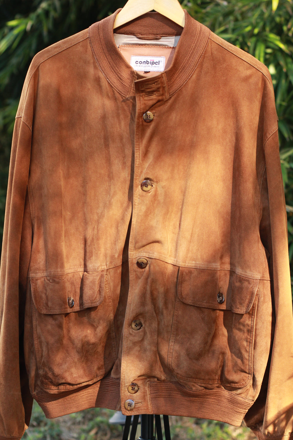 Front view of 1980s brown suede bomber jacket with satin lining