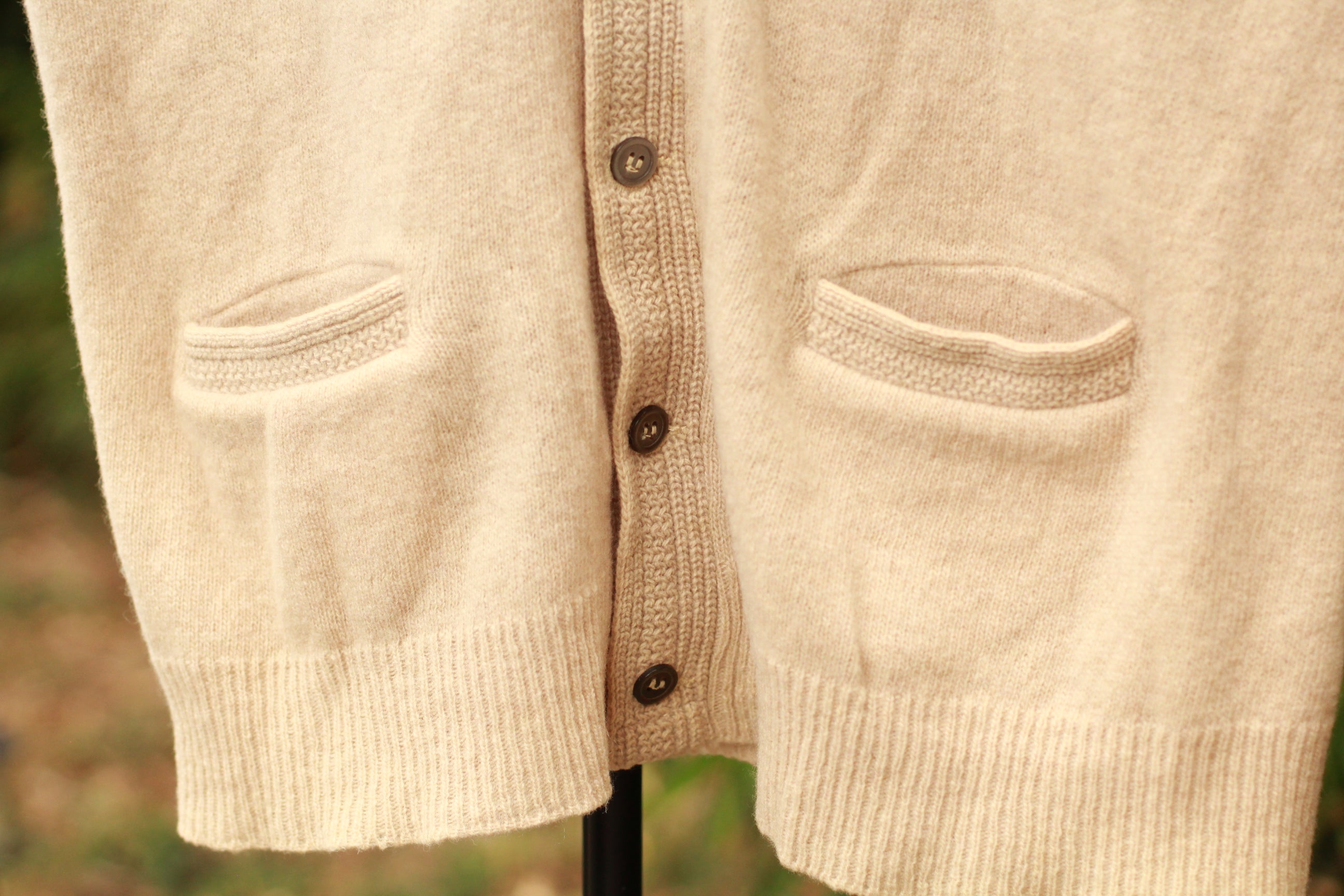 Close-up of knit texture and button detail on vintage sweater vest