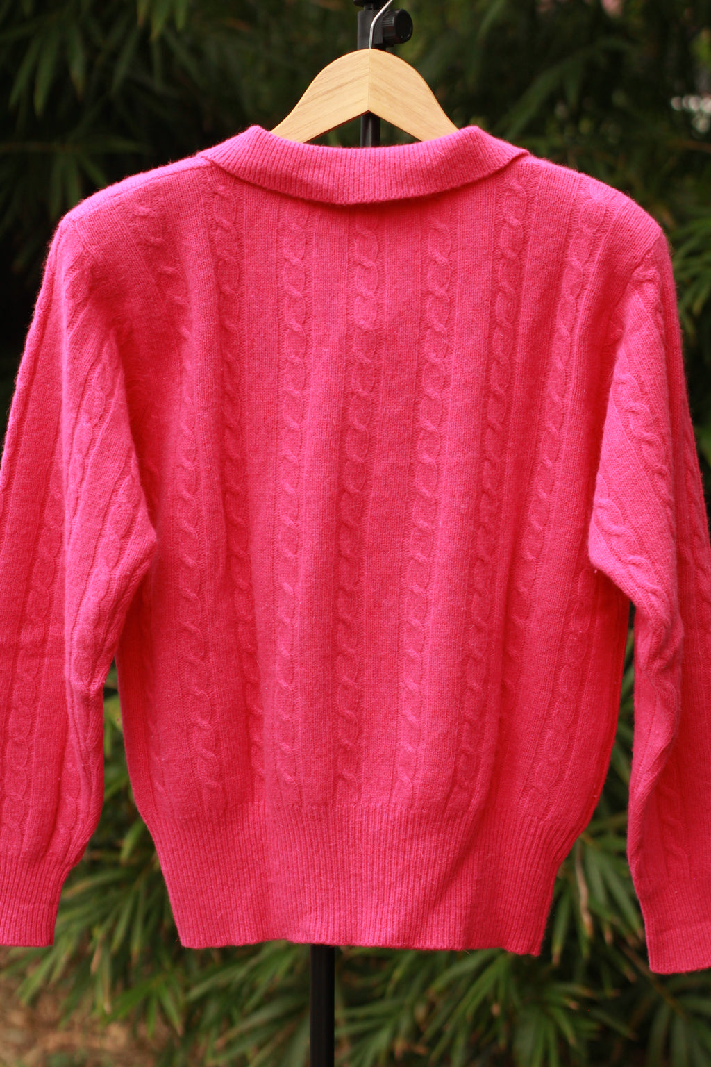 Back view of bright pink 80s–90s sweater with shoulder pads