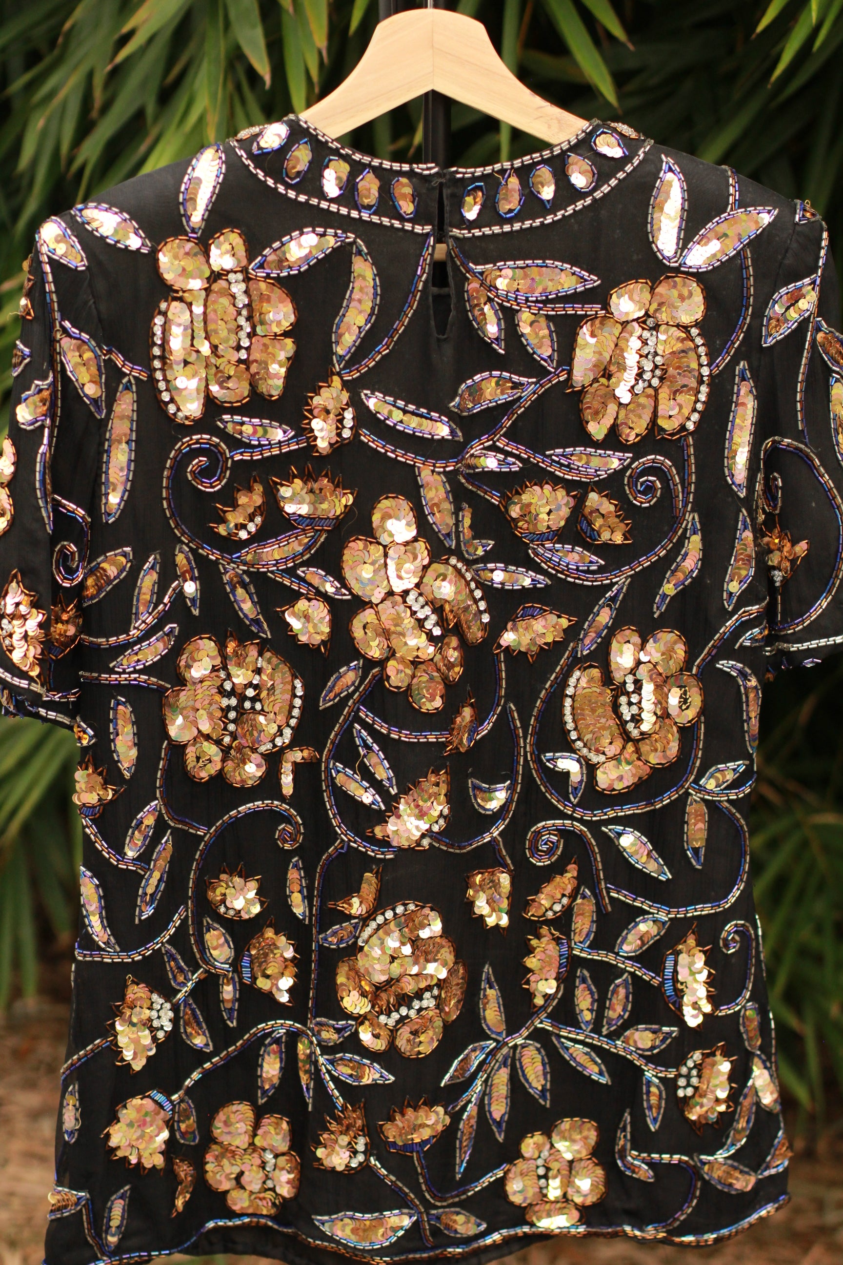 Back view showing round neckline and shoulder pad detail on 1980s evening top