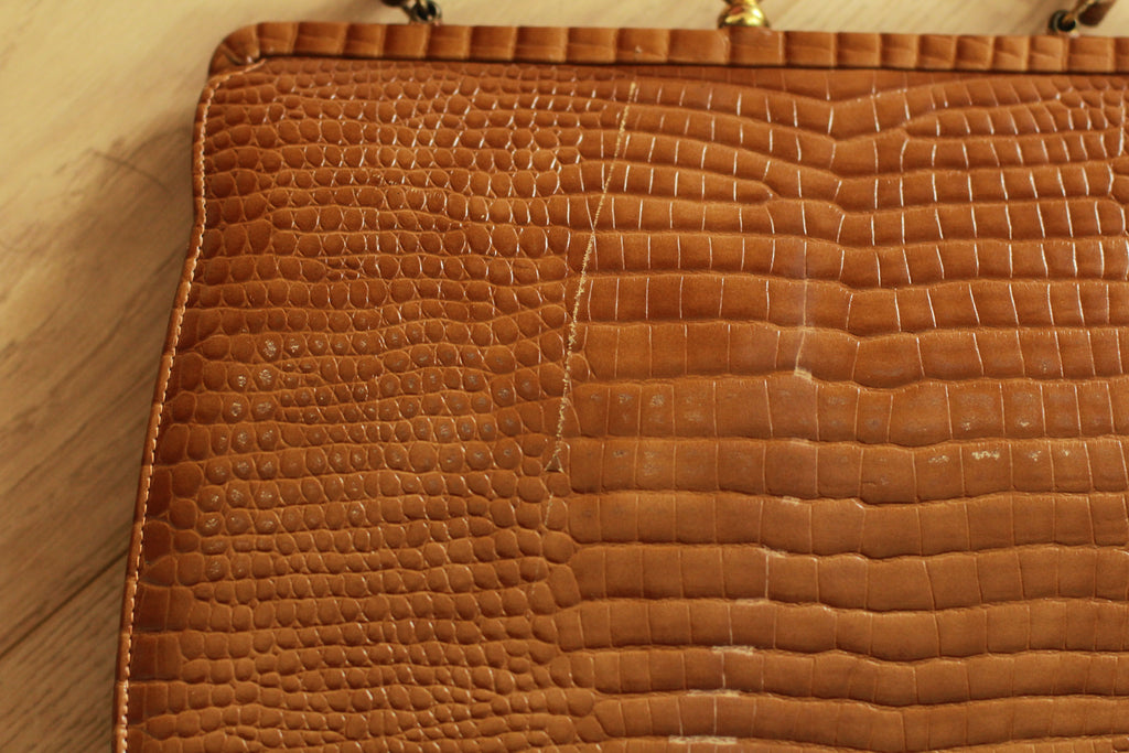 Close-up showing minor vintage scratches on 1960s bag
