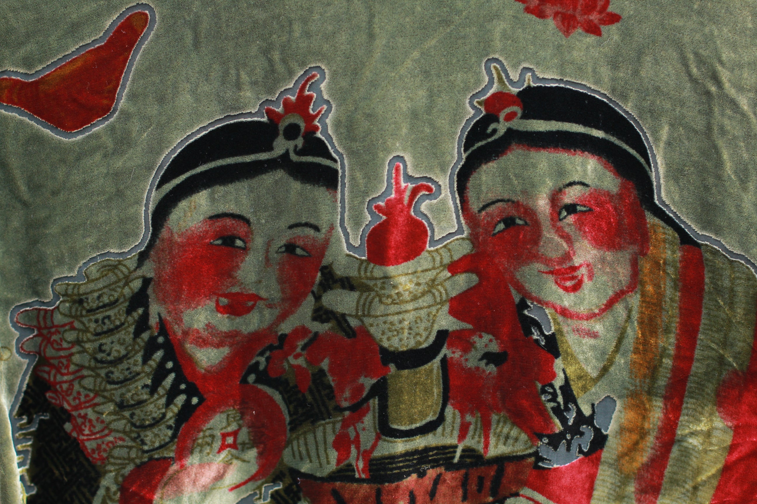 Close-up of red graphic print motifs on dark green velvet