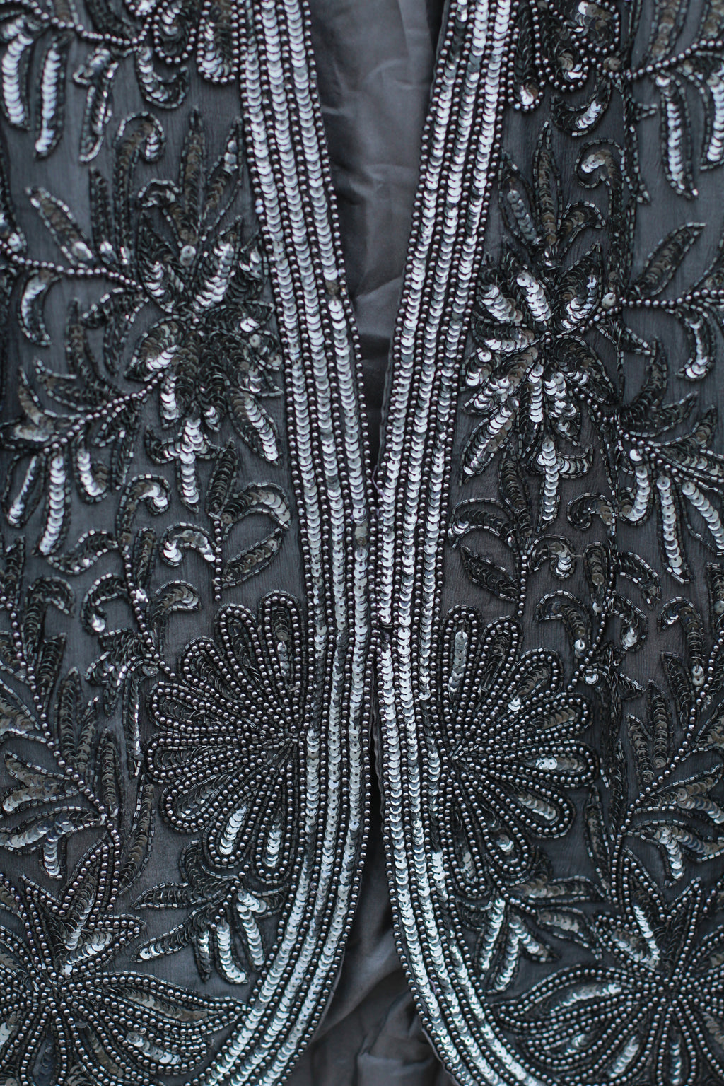 Close-up of intricate beadwork on black silk fabric