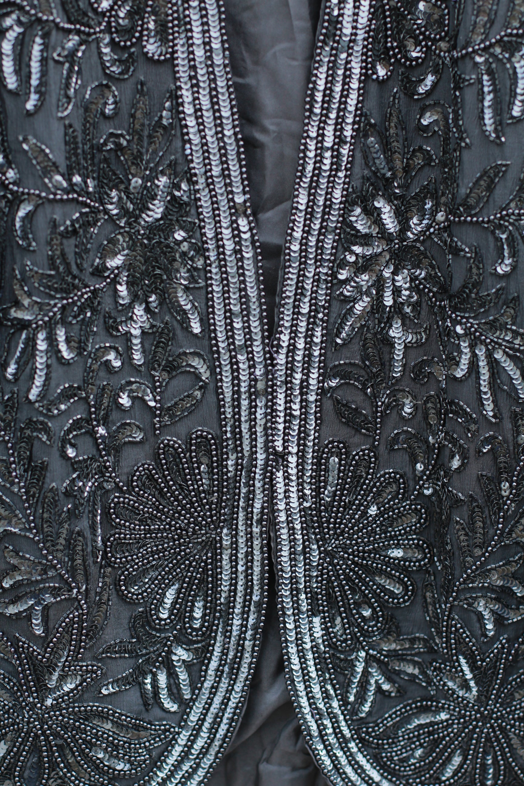 Close-up of intricate beadwork on black silk fabric