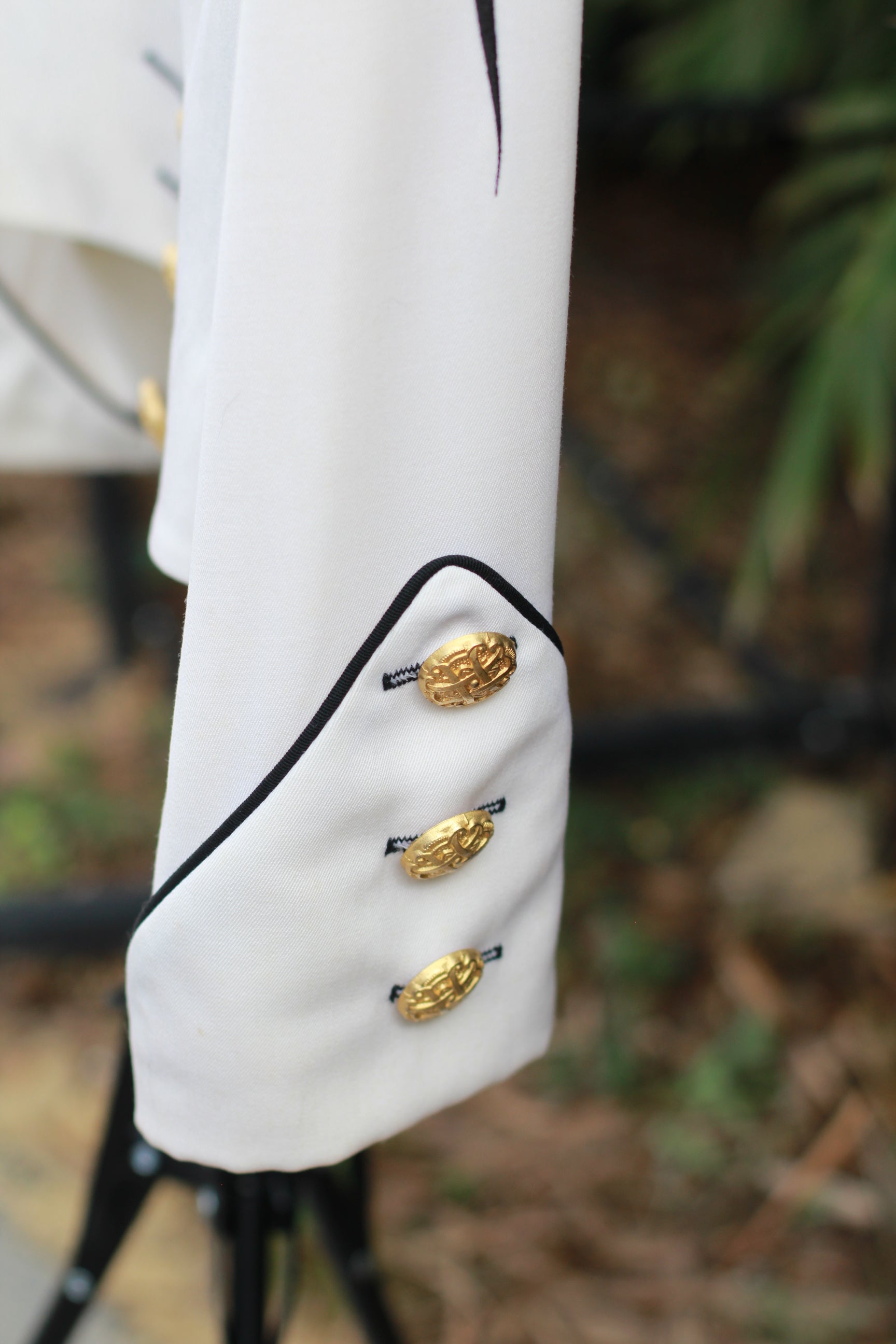 Close-up of gold buttons on arm cuff of vintage CACHÉ jacket.