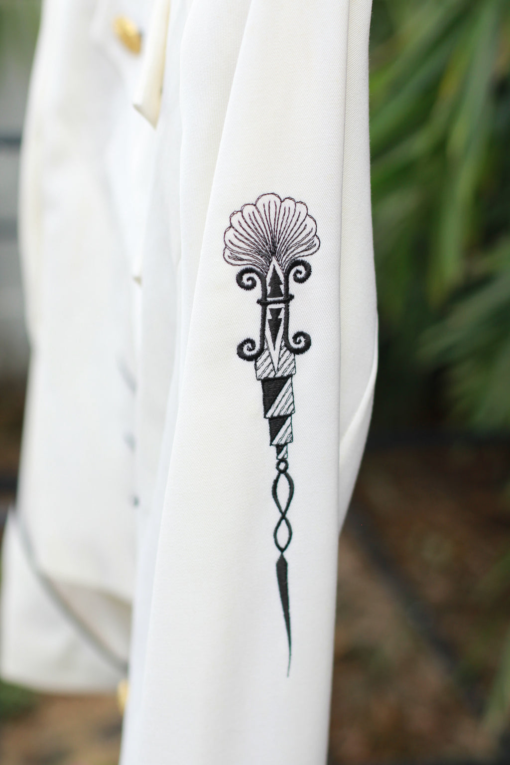 Side view of embroidery detail on sleeve of vintage CACHÉ jacket.