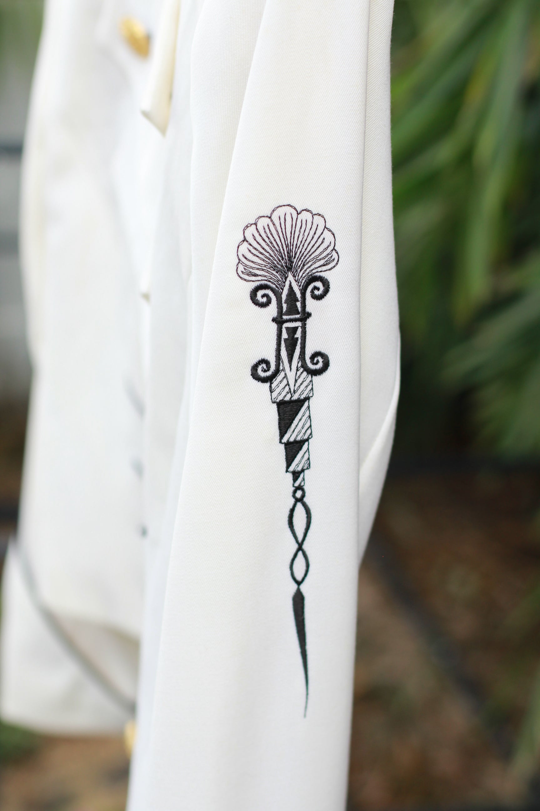 Side view of embroidery detail on sleeve of vintage CACHÉ jacket.