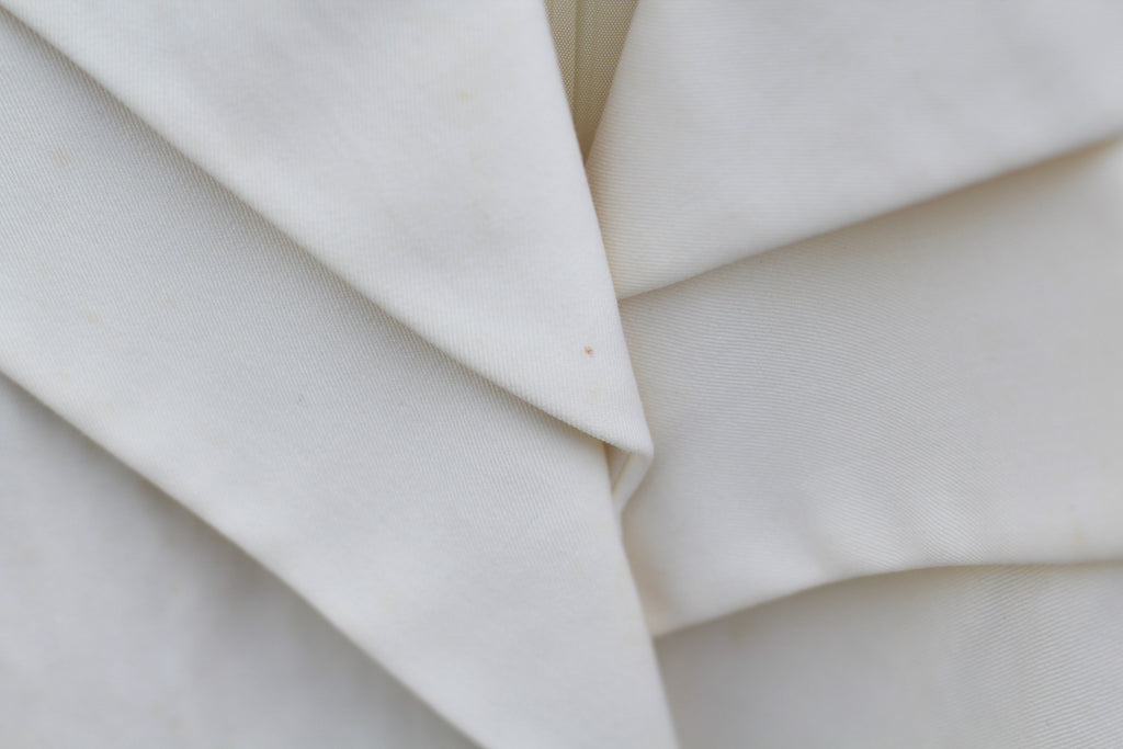 Photographed marks and small stains on vintage cream wool jacket.