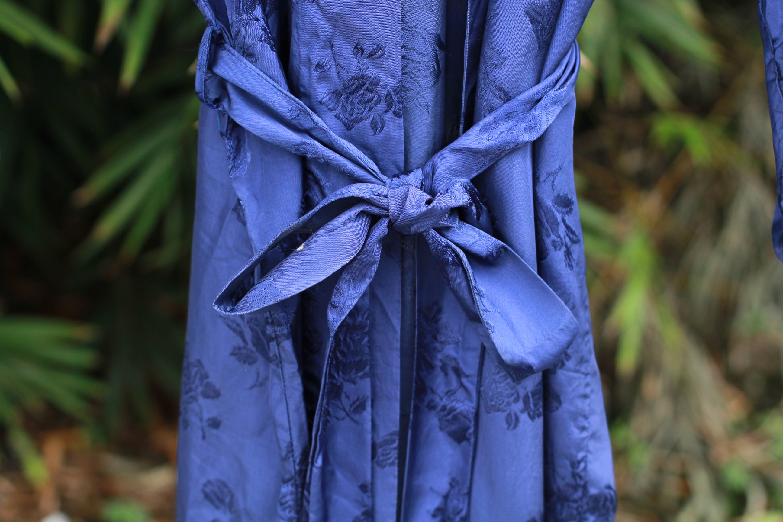Close-up of vintage blue satin kimono robe with waist tie.